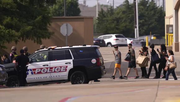 La gente levanta la mano al salir de un centro comercial tras los informes de un tiroteo, el sábado 6 de mayo de 2023, en Allen, Texas. (Foto AP/LM Otero).