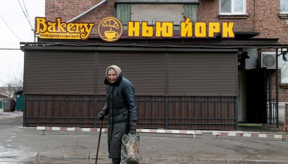 Una anciana ucraniana camina frente a la cafetería "Nueva York", el mismo nombre de su pueblo, ubicado a más de 7.600 kilómetros de distancia de la Gran Manzana, en Estados Unidos. REUTERS/Gleb Garanich/File Photo