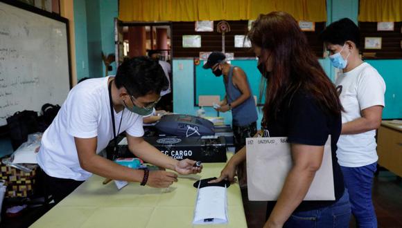 Una mujer tiene el dedo entintado después de emitir su voto en un recinto electoral durante las elecciones nacionales en Manila, Filipinas.