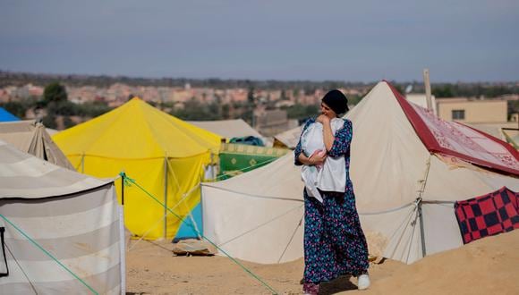 Una mujer carga a un bebé en un campamento de tiendas de campaña en la aldea de Amizmiz, al sur de Marrakech, Marruecos, el 24 de septiembre de 2023. (Foto de EFE/EPA/STR)