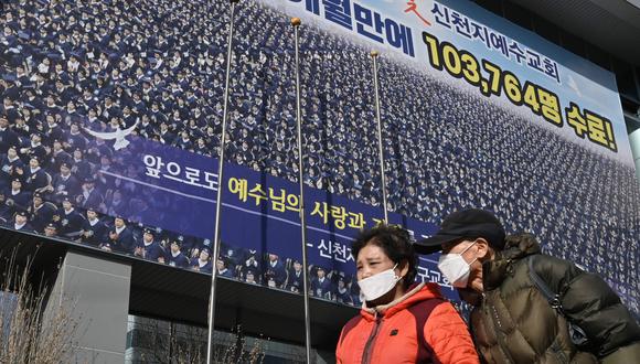 Dos personas que usan máscaras faciales pasan cerca de un templo de la secta Shincheonji en Daegu, Corea del Sur. (AFP / Jung Yeon-je).
