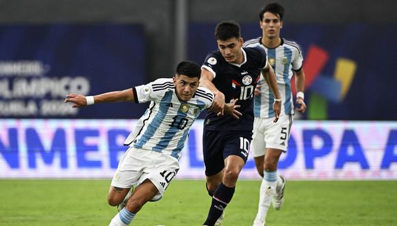 Argentina's Thiago Almada (L) and Paraguay's Wilder Viera (R) fight for the ball during the Venezuela 2024 CONMEBOL Pre-Olympic Tournament football match between Argentina and Paraguay at the Brigido Iriarte stadium in Caracas on February 8, 2024. (Photo by Federico Parra / AFP)