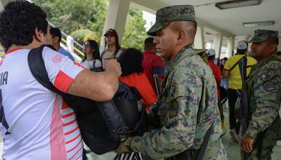 Un soldado inspecciona la mochila de un votante en un colegio electoral en Guayaquil durante la elección presidencial ecuatoriana y el referéndum sobre minería y petróleo, el 20 de agosto de 2023. (Foto: Gerardo MENOSCAL / AFP)