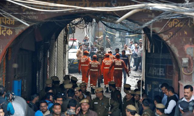 Miembros de la Fuerza Nacional de Respuesta a Desastres de la India (NDRF) se dirigen hacia el sitio del incendio que arrasó una fábrica. (REUTERS / Adnan Abidi).