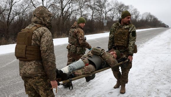 Médicos del ejército ucraniano evacuan a un soldado herido en una carretera no muy lejos de Soledar, región de Donetsk, el 14 de enero de 2023. (Foto: Anatolii Stepanov / AFP)