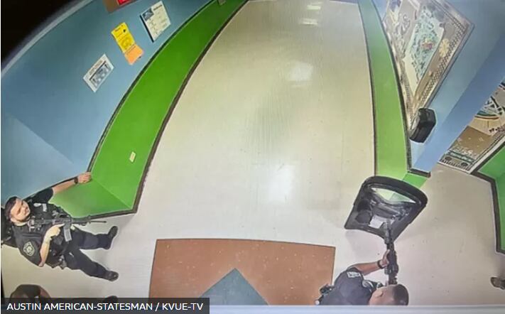 Unreleased footage shows armed police officers waiting in the hallway of the school in Uvalde, Texas.  (AUSTIN AMERICAN-STATESMAN/KVUE-TV).