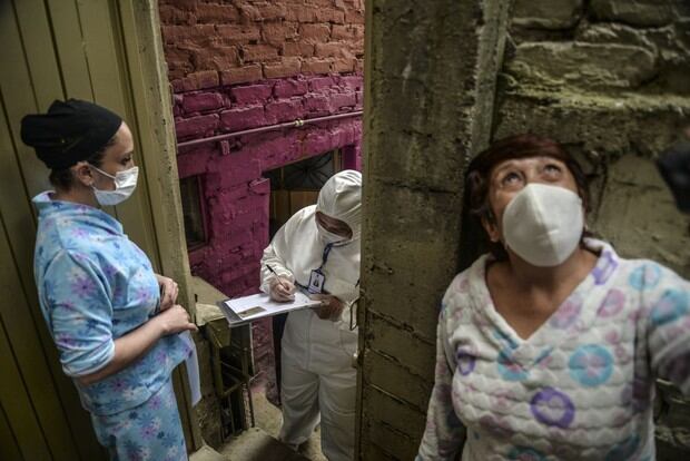 Un trabajador de la alcaldía de Bogotá usa un traje de protección para evitar infectarse con COVID-19, mientras realiza un censo en el vecindario de Egipto en Bogotá para saber cuántas familias deben recibir alimentos para evitarlos ir de compras durante la nueva pandemia (Foto: Diana Sánchez / AFP)