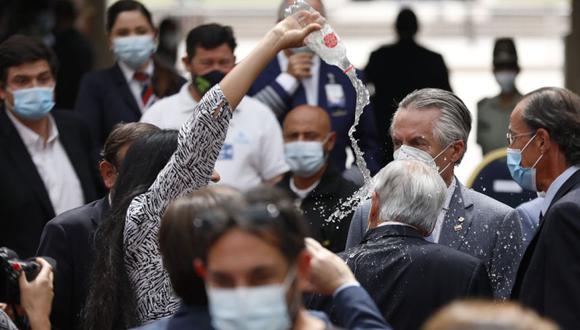 El presidente de Chile Sebastián Piñera (2d), camina mientras una mujer le arroja agua tras un acto en el Palacio de La Moneda en Santiago (Chile). (Foto: EFE/ATON CHILE/Dragomir Yankovic).