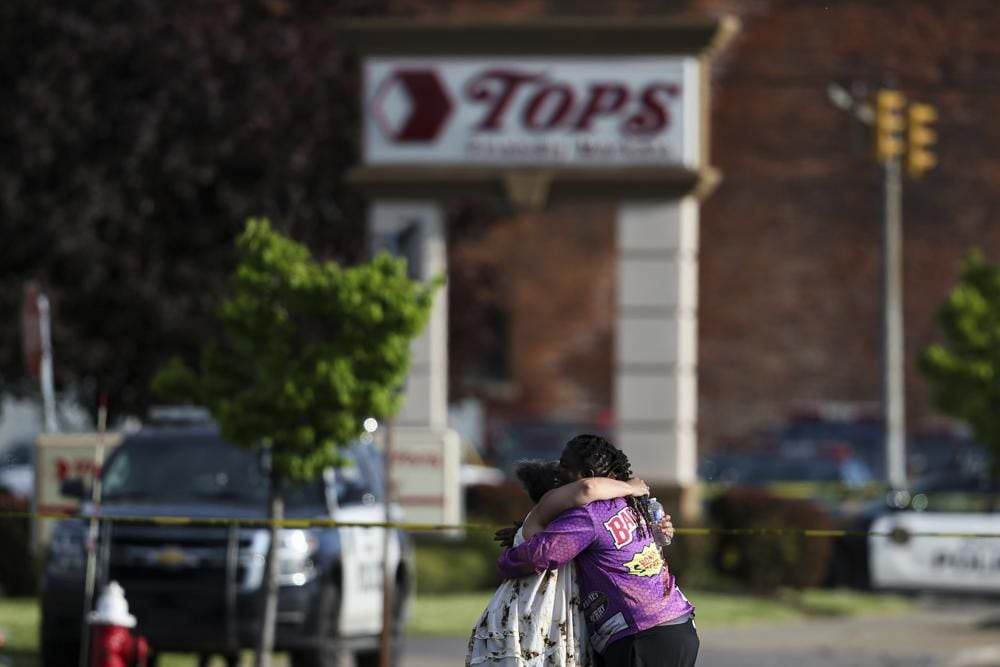 Two people embrace outside the scene of a shooting at a supermarket in Buffalo, New York, USA.  (AP Photo/Joshua Bessex)