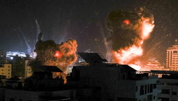 Las explosiones iluminan el cielo de la ciudad de Gaza mientras las fuerzas de Israel bombardean el enclave palestino el 18 de mayo de 2021. (Foto de MAHMUD HAMS / AFP).