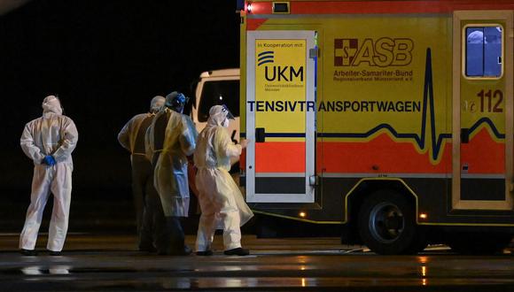 Médicos que usan EPP transportan pacientes infectados con el coronavirus a otras unidades de cuidados intensivos (UCI) desde un MedEvac de las fuerzas armadas de Alemania, el 26 de noviembre de 2021. (INA FASSBENDER / AFP).