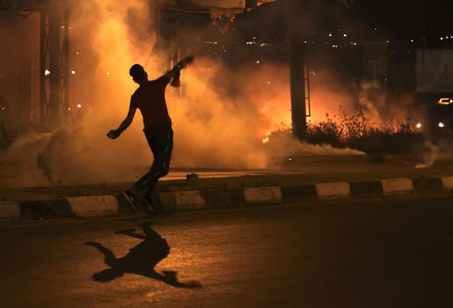 Los manifestantes palestinos queman neumáticos en medio de enfrentamientos con las fuerzas de seguridad israelíes en el puesto de control de Hawara, al sur de la ciudad de Naplusa, en la ocupada Cisjordania. (Foto de JAAFAR ASHTIYEH / AFP).