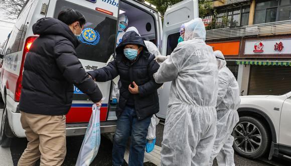 La imagen muestra a un paciente atendido por miembros del personal médico que usan ropa protectora para ayudar a evitar la propagación del virus. (Foto: AFP)
