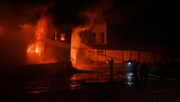 El personal de emergencia ucraniano rocía agua para extinguir las llamas después de que estallara un incendio en el lugar de un ataque con drones en Kharkiv, a primera hora del 10 de febrero de 2024. (Foto de SERGEY BOBOK / AFP)