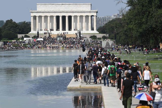Los manifestantes caminan hacia el Lincoln Memorial para la protesta "Marcha del compromiso: quítese las rodillas del cuello" contra el racismo y la brutalidad policial (Foto: AFP)