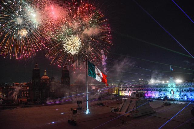 Luces y fuegos artificiales en el cielo de la Plaza del Zócalo durante la ceremonia del 211 aniversario del Grito de Independencia en Ciudad de México. (EFE/ Mario Guzmán).