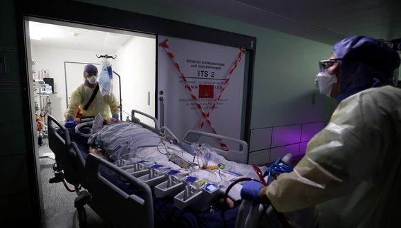 Medical personnel wear personal protective equipment (PPE) as they transport a Covid-19 patient connected to an artificial heart-lung device known as extracorporeal membrane oxygenation, or ECMO, to a computerised tomography (CT) scan at the University Medical Center Magdeburg (UMMD) in Magdeburg, eastern Germany, on December 10, 2021, amid the novel coronavirus COVID-19 pandemic. - The EU health agency ECDC on December 15, 2021 warned that vaccinations alone would not stop the rise of the Omicron variant of the novel coronavirus, and said "strong action" was urgently needed. (Photo by Ronny Hartmann / AFP)