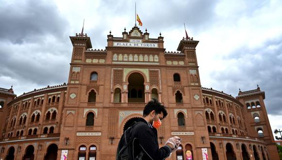 Un hombre que llevaba una mascarilla para protegerse del coronavirus pasa por la plaza de toros de Las Ventas en Madrid el 22 de abril de 2020. (Foto de Gabriel BOUYS / AFP).