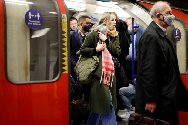 Commuters with and without masks on a Transport for London (TfL) underground train in London, on January 31, 2022. (Tolga Akmen / AFP)