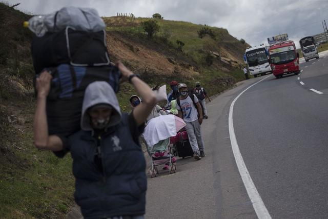 Los migrantes venezolanos caminan hacia Bogotá a su paso por Tunja, Colombia. Miles de venezolanos se dirigen a Colombia, Ecuador y Perú en busca de trabajo mientras estos países reabren sus economías luego de meses de bloqueos.. (AP/Ivan Valencia).