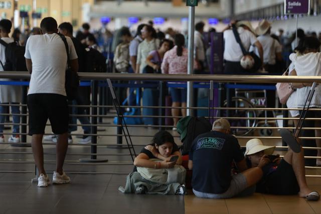 Pasajeros deciden esperar sus vuelos sentados en el piso del Aeropuerto Jorge Chávez. (Foto: Julio Reaño/@Photo.gec)