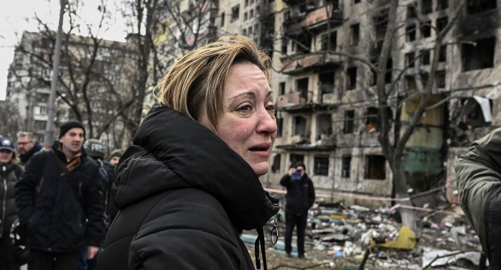 Una mujer llora frente a los bloques de apartamentos destruidos tras los bombardeos rusos en el distrito de Obolon, en el noroeste de Kiev, Ucrania, el 14 de marzo de 2022. (ARIS MESSINIS / AFP).