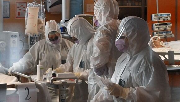 Trabajadores médicos en un tendón de equipo de protección (trasero R) el 24 de marzo de 2020 en la nueva unidad de cuidados intensivos de 3 niveles para casos COVID-19 en el hospital Casal Palocco cerca de Roma. (AFP)