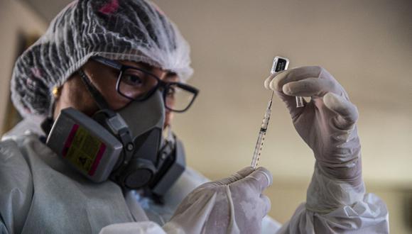 Un trabajador de salud prepara una vacuna Pfizer-BioNTech contra Covid-19 en una casa en Lima el 8 de marzo de 2021. (Foto: AFP)
