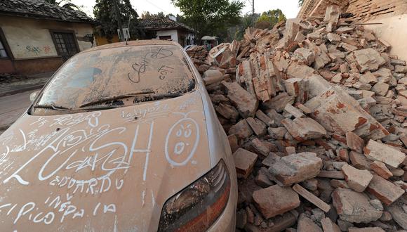 Un automóvil junto a los escombros en Curicó, 250 km al sur de Santiago, tras un terremoto de magnitud 8,8 en Chile, el 27 de febrero de 2010. (Foto de MARTIN BERNETTI / AFP)
