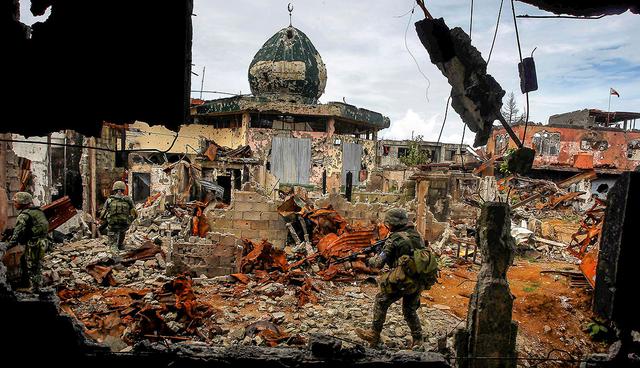Government soldiers from the Philippine Marines 1st Brigade patrol past damaged buildings as troops continue their assault on clearing operations against the pro-IS militant group in Marawi city, southern Philippines, September 14, 2017.  REUTERS/Marconi Navales