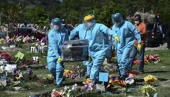 Empleados del cementerio portan el féretro del periodista Carlos Riedel fallecido por coronavirus COVID-19 en Tegucigalpa, el 20 de junio de 2021. (Foto de Orlando SIERRA / AFP).