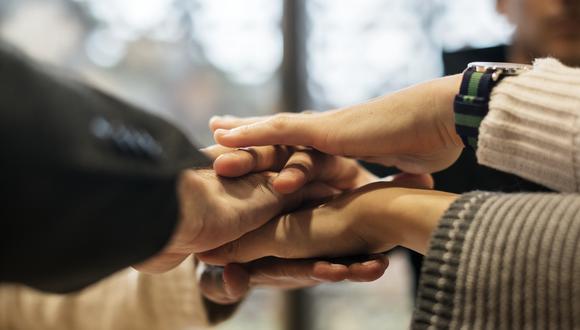 Diverse people stacking hands together