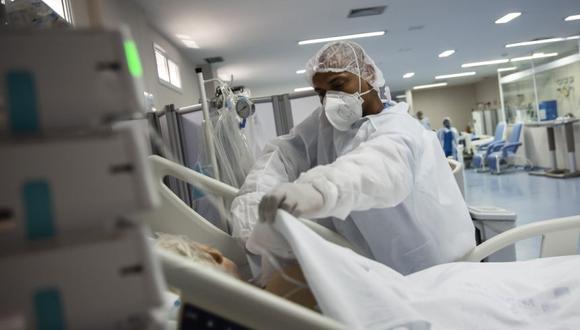Un enfermero coloca una manta sobre un paciente con COVID-19 en la unidad de cuidados intensivos del hospital Dr. Ernesto Che Guevara en Marica, Brasil. (Foto: AP/Bruna Prado)