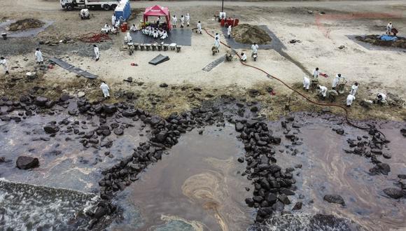 Personal contratado por Repsol intenta juntar a mano el petróleo acumulado en la playa Cavero de Ventanilla, una de las más afectadas. | Foto: GEC