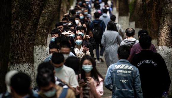 Esta foto tomada el 28 de abril de 2021 muestra a estudiantes universitarios haciendo cola para recibir la vacuna contra el coronavirus del Grupo Nacional Biotec de China (CNBG) en una universidad de Wuhan, en la provincia central china de Hubei. (STR / AFP).
