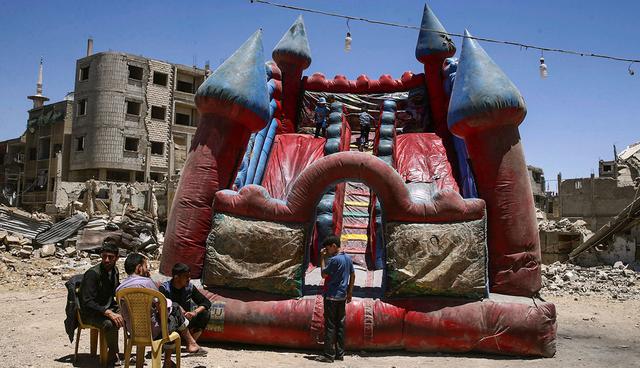Children play inside an inflatable castle during Eid al-Fitr celebration in the rebel-held besieged Douma neighbourhood of Damascus, Syria June 26, 2017. REUTERS/Bassam Khabieh        TPX IMAGES OF THE DAY
