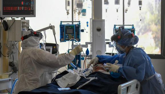 Medical staff tend to a patient at the intensive care unit for patients patients infected with Covid-19 at the Trinidad Teaching Medical Center, in Caracas, on March 19, 2021. (Photo by Federico PARRA / AFP)