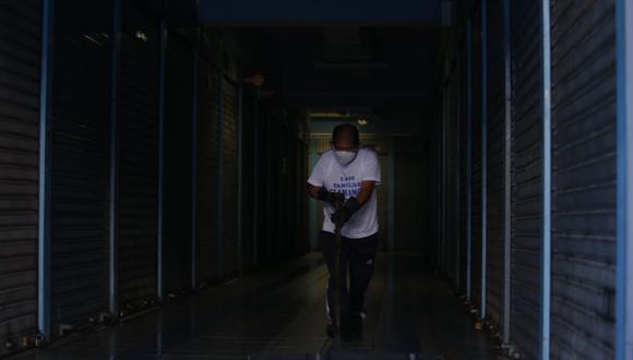 Una persona limpia uno de los pasadizos del centro comercial Polvos Azules, en La Victoria, cuyas tiendas fueron cerradas por el estado de emergencia. (Foto: GEC).