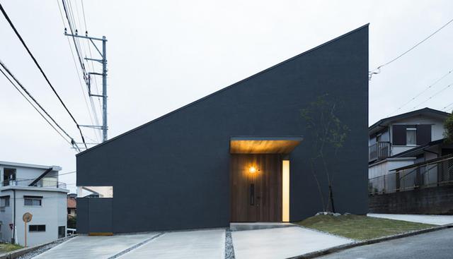 Desde la fachada ya se puede notar que la simplicidad será la protagonista de esta casa. El color oscuro contrasta con la madera clara de la puerta de entrada y las pocas ventanas. (Foto: tukurito.com)