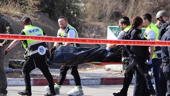 Agentes de emergencia israelí Magen David Adom llevan una bolsa para cadáveres después de un ataque de hombres armados a un puesto de control que une la Cisjordania ocupada por Israel y Jerusalén el 16 de noviembre de 2023. (Foto de AHMAD GHARABLI / AFP)