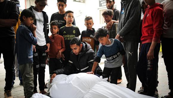 Dolientes se encuentran cerca de los cadáveres de un adulto y un niño muertos en un bombardeo israelí nocturno, frente a la morgue de un hospital en Rafah, en el sur de la Franja de Gaza, el 27 de abril de 2024. (Foto de AFP)