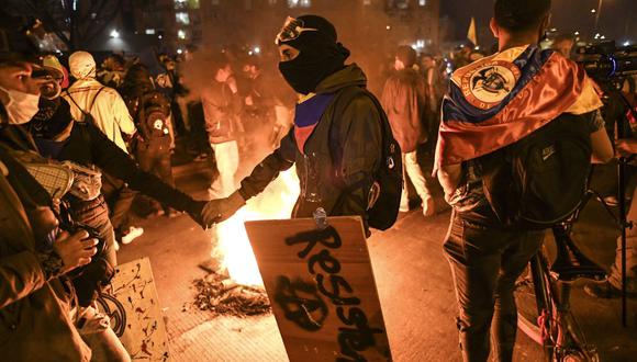 Manifestantes marchan alrededor de una barricada de fuego, durante una nueva protesta contra el gobierno del presidente Iván Duque en Portal De Las Américas, al sur de Bogotá. (Foto de Juan BARRETO / AFP).