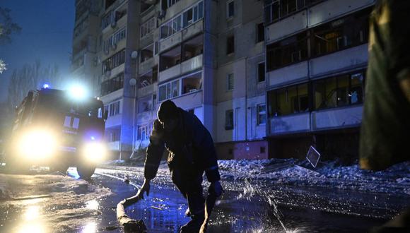 Un bombero del Servicio de Emergencia de Ucrania trabaja junto a un edificio residencial dañado, luego de un ataque ruso en la ciudad de Vyshgorod, en las afueras de Kiev, el 23 de noviembre de 2022. (GENYA SAVILOV / AFP).