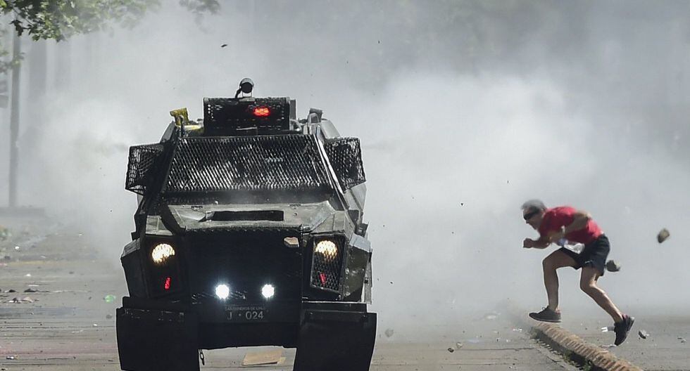 Un vehículo de la policía es apedreado en Santiago. (AFP / Martin BERNETTI).