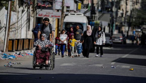 Un hombre empuja a una anciana en silla de ruedas mientras los habitantes evacuan la ciudad de Gaza en medio de un aumento de las operaciones militares en la Franja de Gaza, este miércoles | Foto: EFE/MOHAMMED SABER