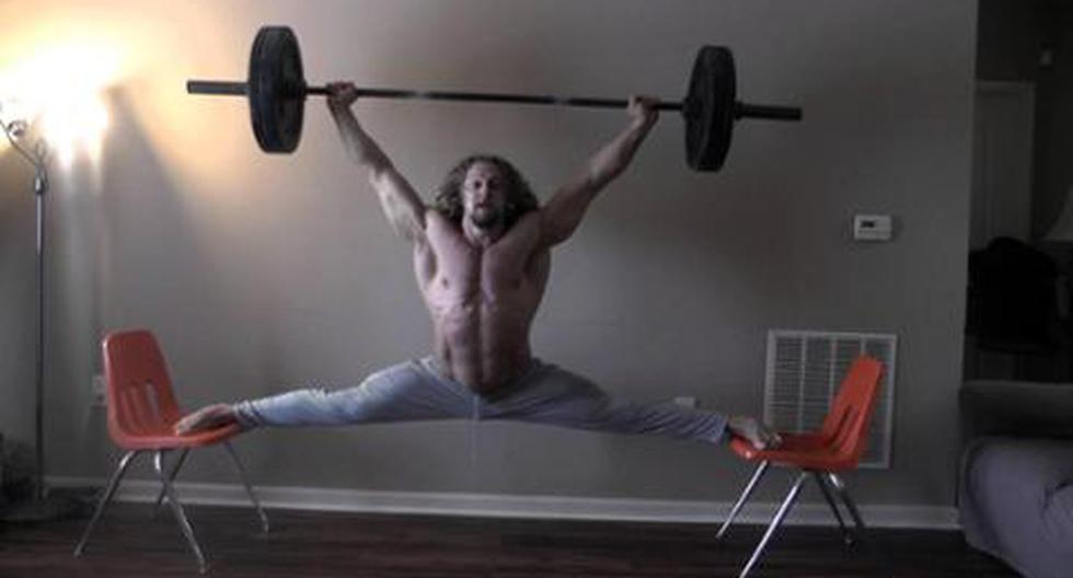 Strong Man Holds Barbell Above His Head While Performing Splits