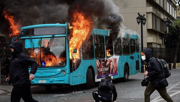 Un autobús arde en llamas tras ser alcanzado por una bomba incendiaria lanzada durante una marcha de estudiantes para exigir al gobierno mejoras en el sistema educativo en Santiago.