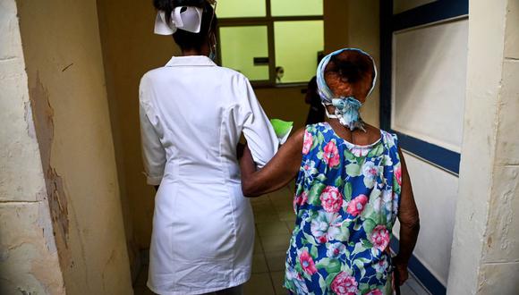 Una enfermera acompaña a una anciana para ser inoculada contra el coronavirus COVID-19 con la vacuna cubana Abdala en La Habana, el 2 de agosto de 2021. (YAMIL LAGE / AFP).