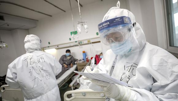 Médicos con traje de protección verifican los registros de un paciente en el hospital Jinyintan en Wuhan, el epicentro del nuevo brote de coronavirus. (Foto referencial / Reuters).