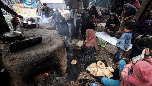 Mujeres palestinas abren hornos en un campamento improvisado que alberga a palestinos desplazados, en Rafah, en el sur de la Franja de Gaza, en medio del conflicto en curso entre Israel y el grupo militante Hamás, el 2 de enero de 2024. (Foto de AFP)